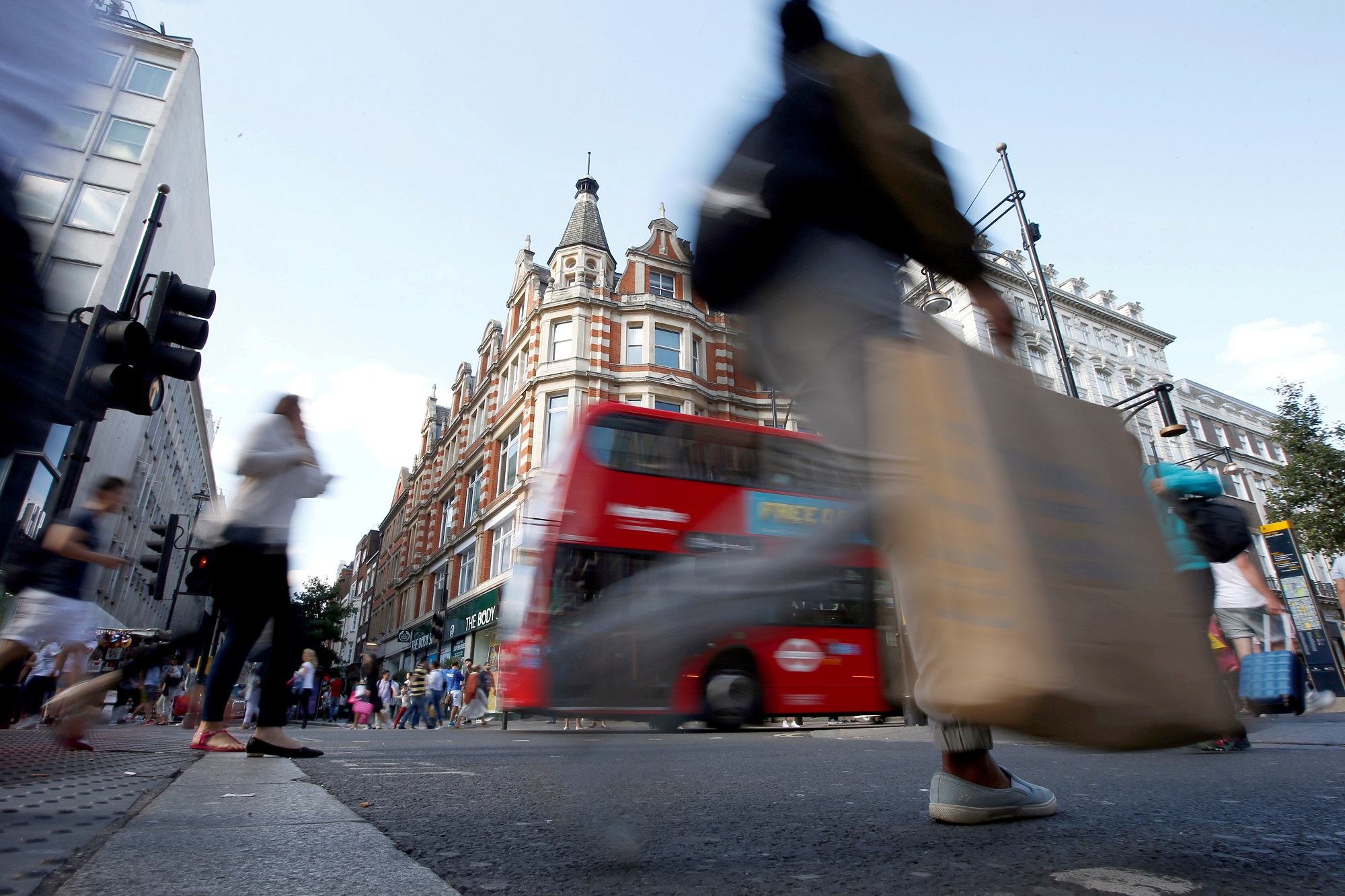 متسوقون يعبرون شارعا في لندن. (رويترز)