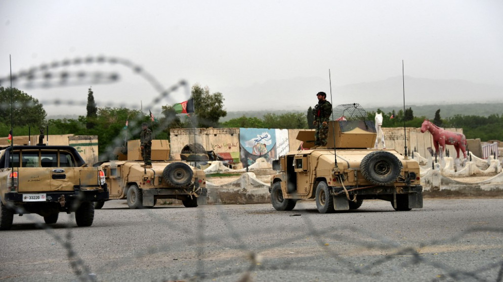 رجال أمن أفغانيون يقفون على مركبات عسكرية. (أ ف ب)