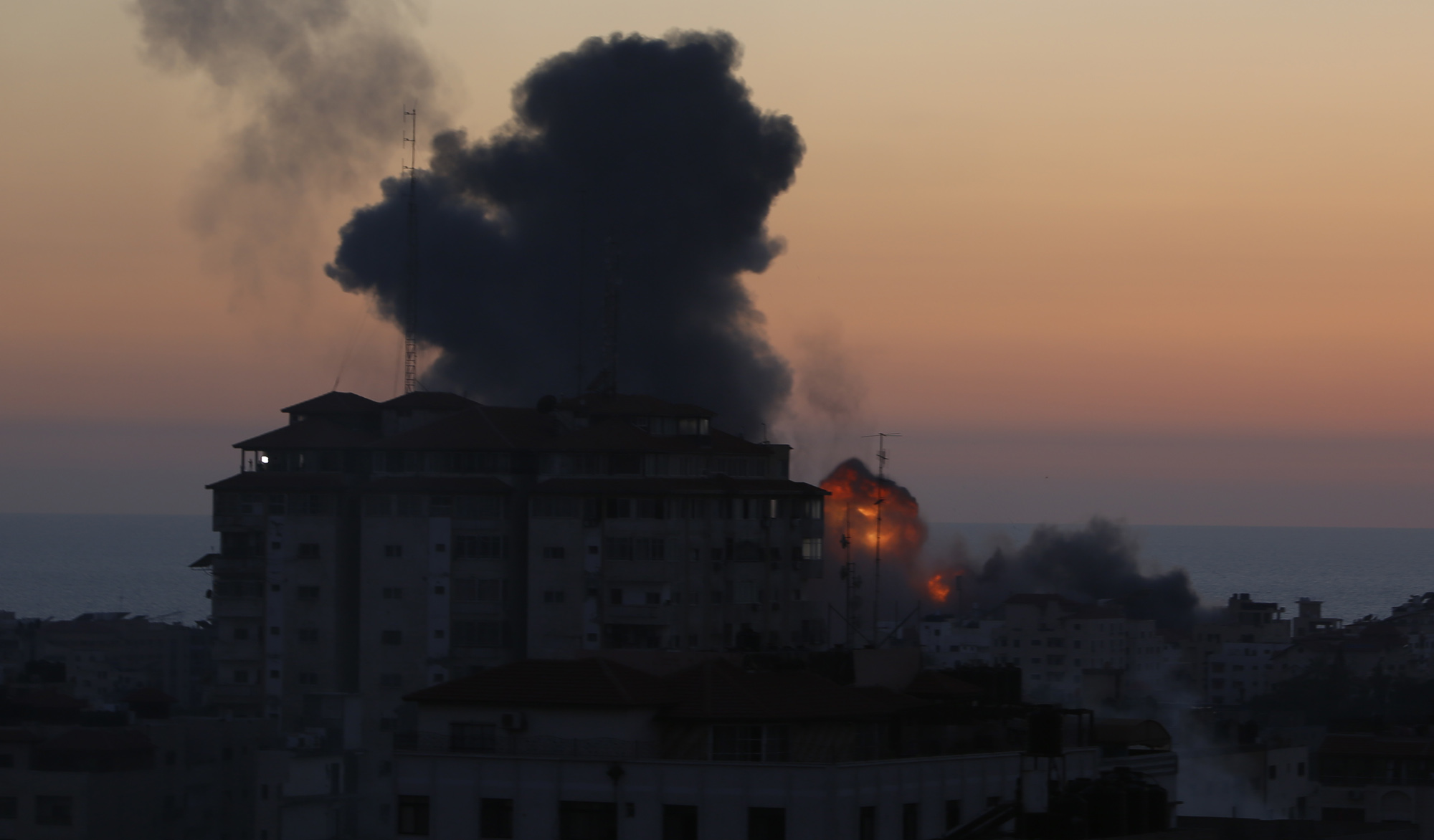 نار ودخان يتصاعدان من مبنى في قطاع غزة بعد استهدافة من طائرات الاحتلال الإسرائيلي 14/05/2021. (حاتم موسى/ وفا)