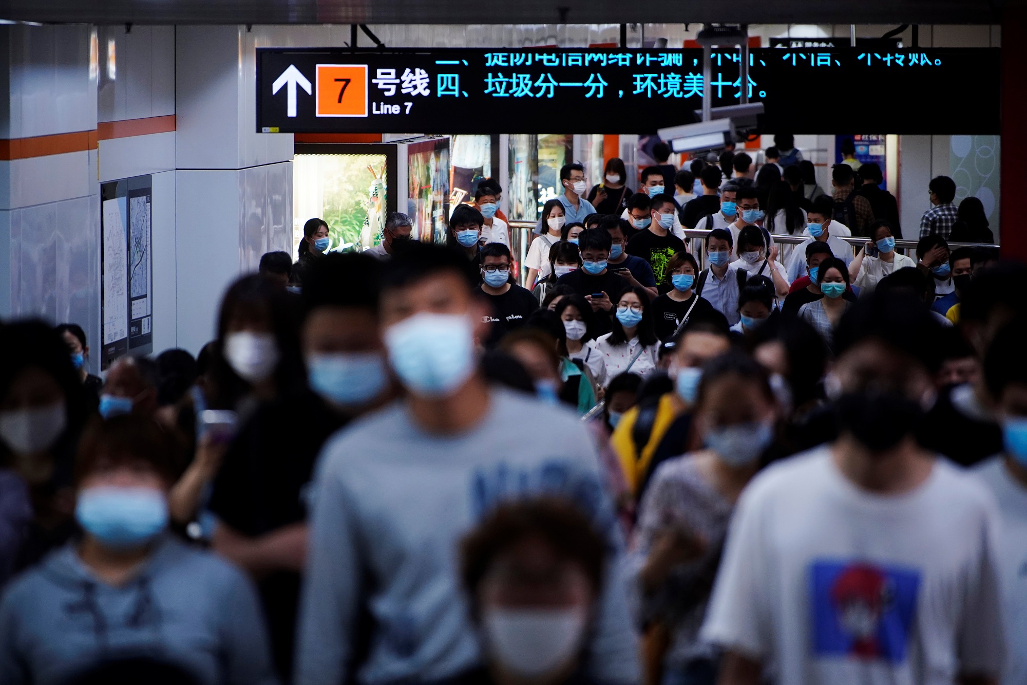 أشخاص يردتون الكمامات ويسيرون في محطة مترو أنفاق، في شنغهاي، الصين، 11 أيار/مايو 2021. (رويترز)