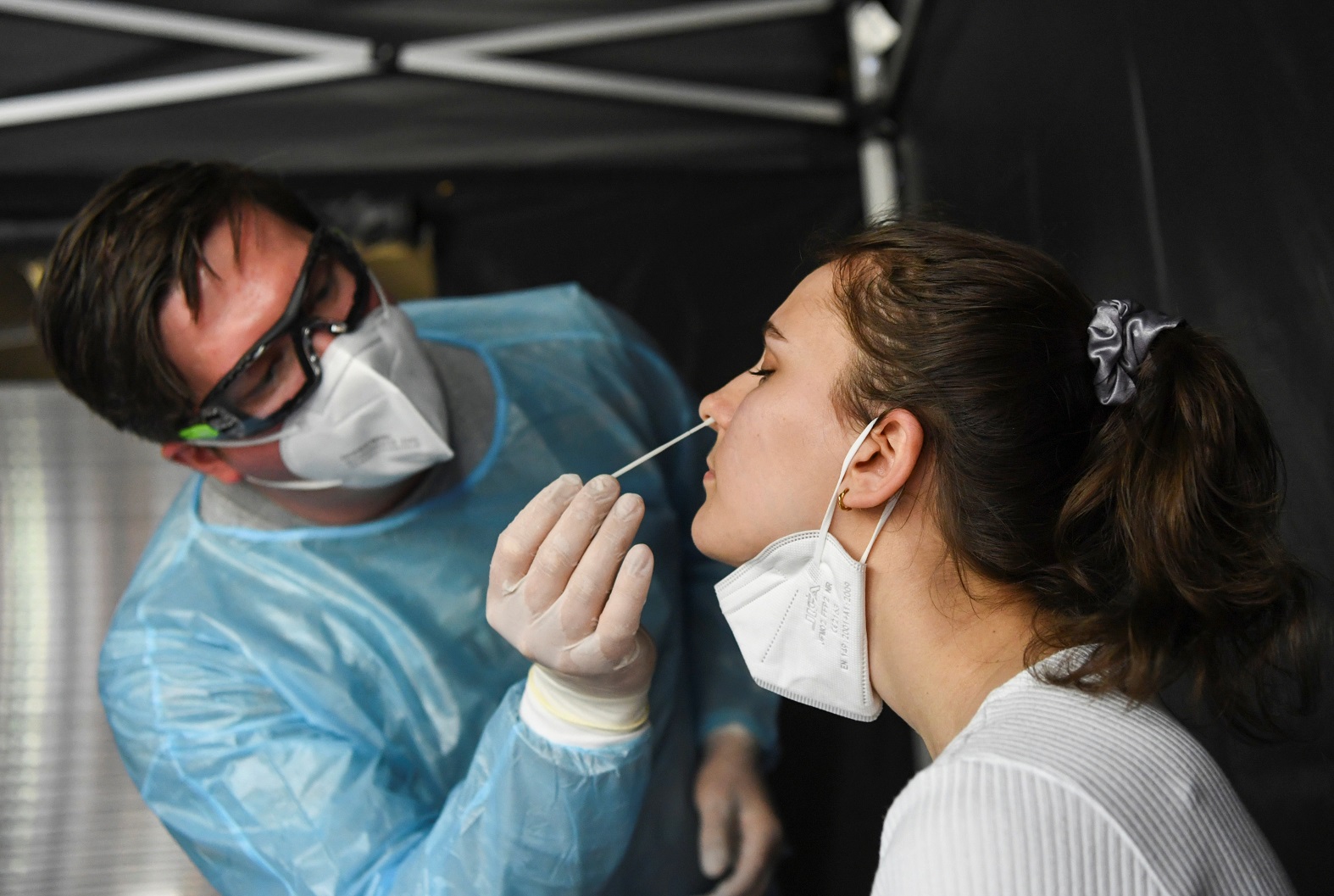 عامل رعاية صحية يأخذ مسحة من شخص أثناء اختبار فيروس كورونا (COVID-19)، في برلين، ألمانيا، 11 أيار/مايو 2021. (رويترز)