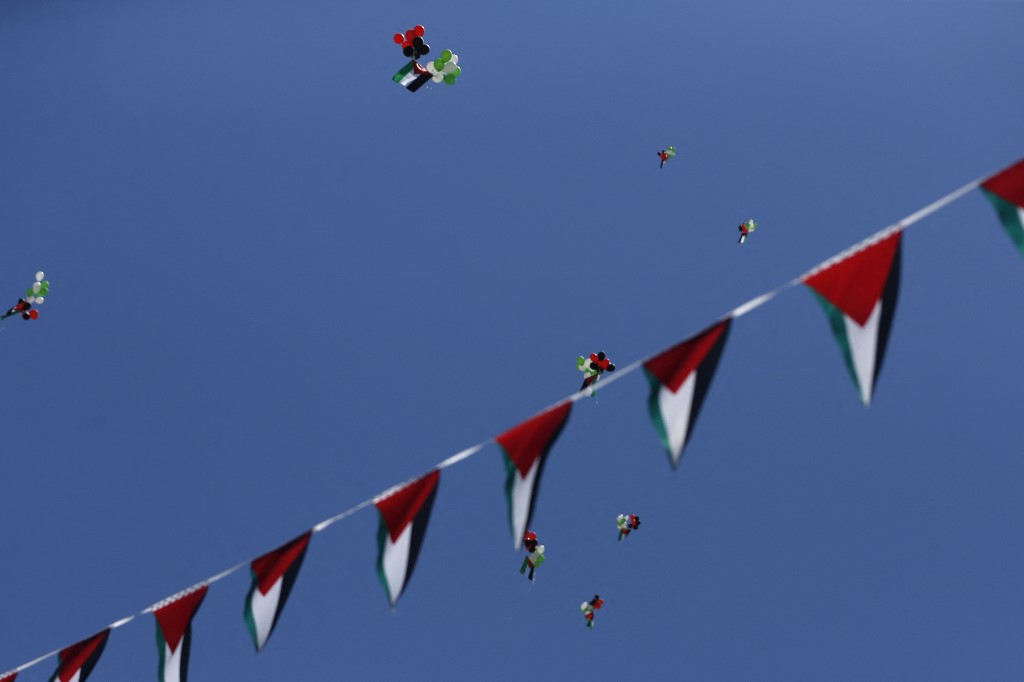 إطلاق بالونات تحمل ألوان العلم الفلسطيني خلال مسيرة لإحياء الذكرى الثالثة والسبعين للنكبة عام 1948 ، في مدينة رام الله المحتلة بالضفة الغربية .15 مايو 2021.(أ ف ب)