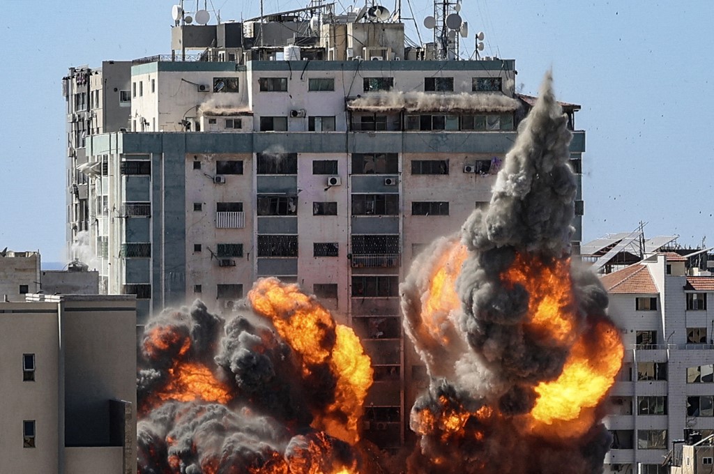 اندلاع النيران من برج الجلاء بعد تدميره بواسطة غارة جوية إسرائيلية على مدينة غزة، 15 مايو 2021. (أ ف ب)