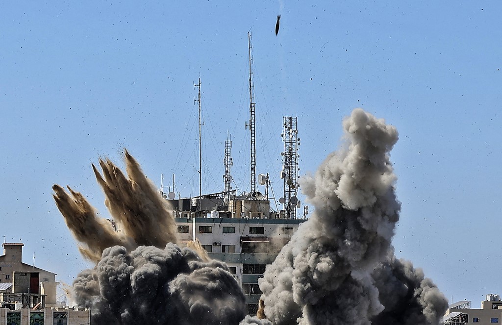 دخان يتصاعد نتيجة إلقاء قنبلة جوية على برج الجلاء بواسطة غارة جوية إسرائيلية على مدينة غزة، 15 مايو 2021. (أ ف ب)