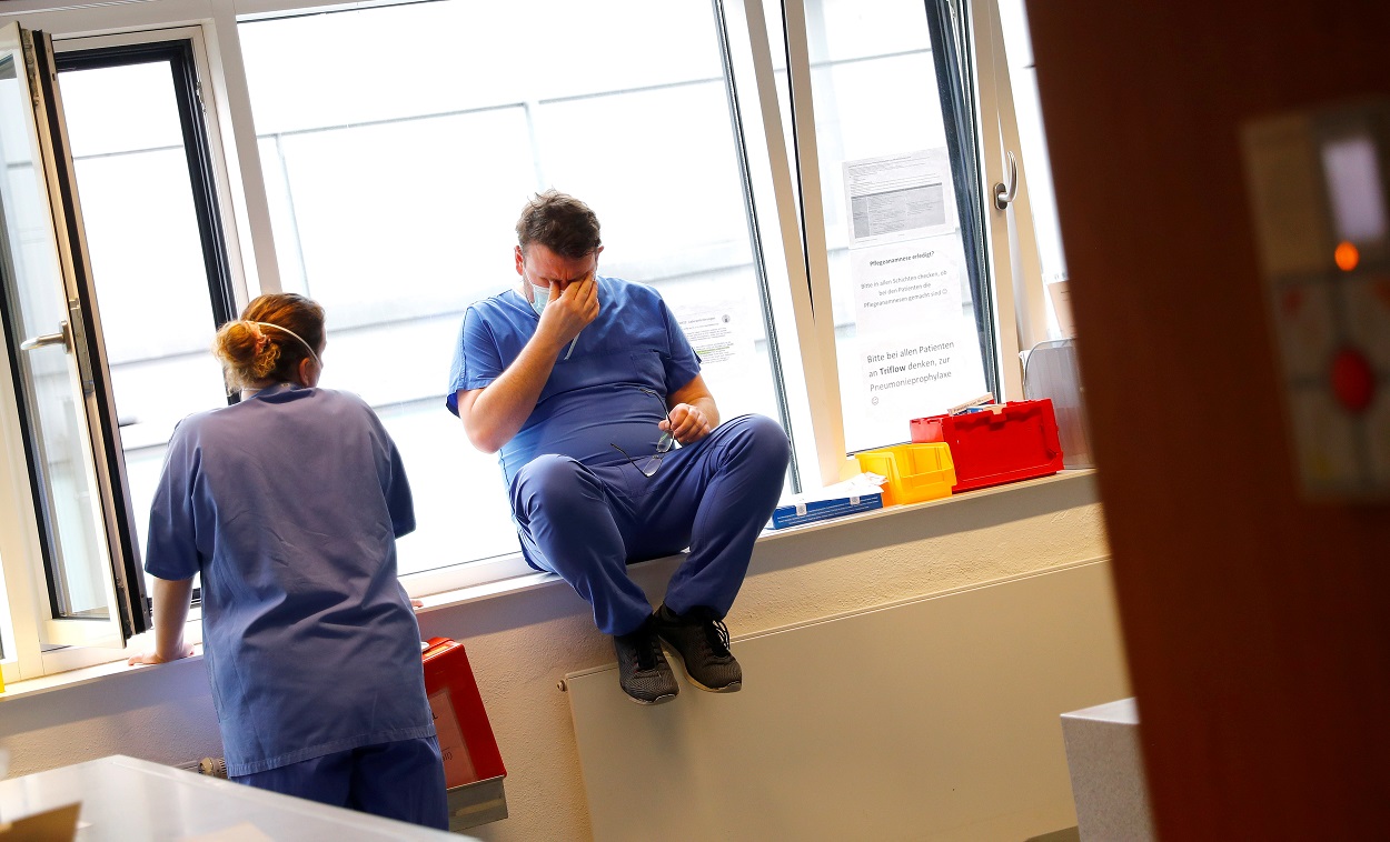 ممرضة وممرض يأخذان استراحة بعد علاج المرضى الذين يعانون من فيروس كورونا، في عيادة في دارمشتات، ألمانيا، 11 مايو 2021. (رويترز)