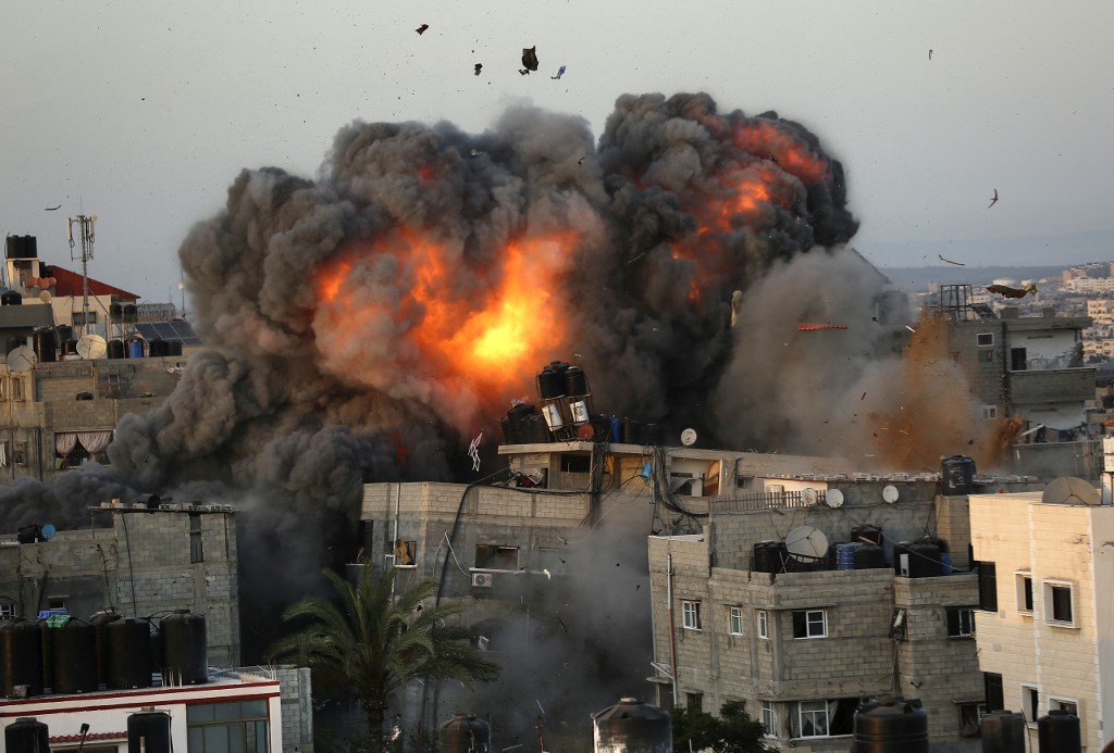 اندلاع النيران من مبنى في حي الرمال السكني بمدينة غزة، جراء القصف الإسرائيلي، 16 مايو 2021. (أ ف ب)