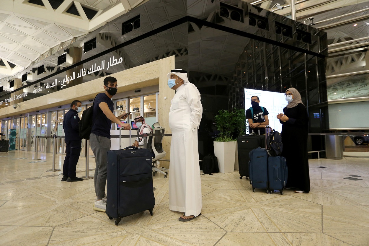 سعوديون ينتظرون دورهم في تسجيل أمتعتهم في مطار الملك خالد الدولي، بعد أن رفعت السلطات السعودية حظر سفر مواطنيها بعد أربعة عشر شهرًا بسبب قيود فيروس كورونا، الرياض، السعودية، 16 مايو 2021. (رويترز)