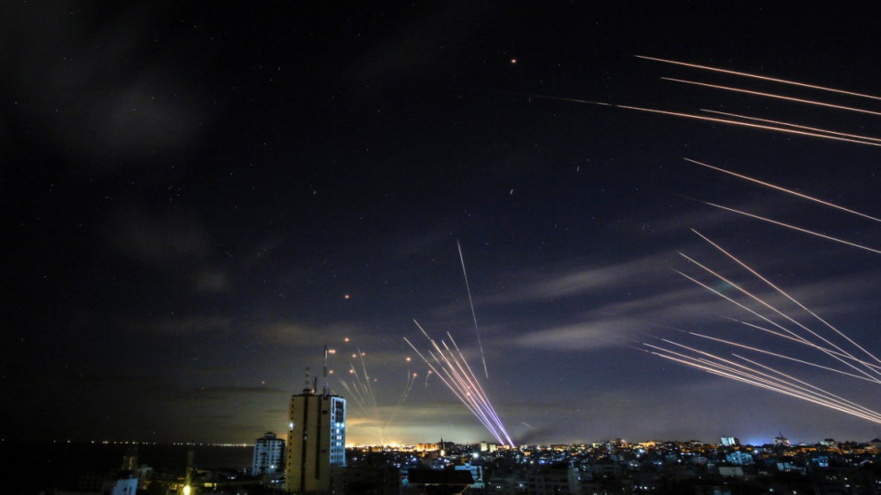 نظام القبة الحديدية (يسار) يحاول اعتراض صواريخ المقاومة الفلسطينية (يمين) التي أُطلقت من بيت لاهيا في شمال قطاع غزة، 16 أيار/مايو 2021. (أ ف ب)