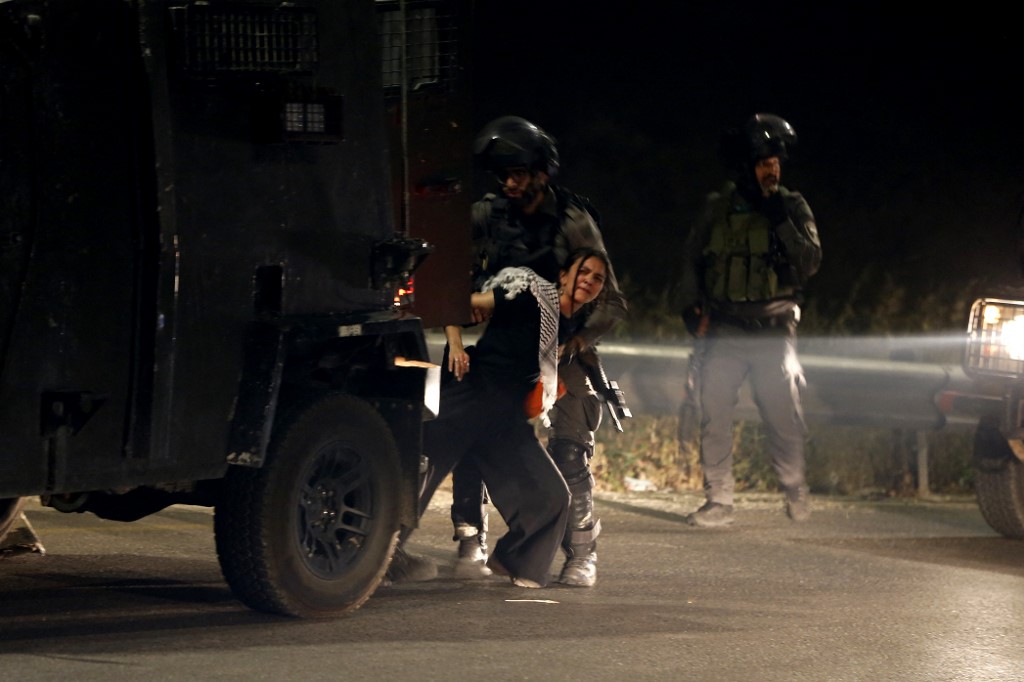 جنود من جيش الاحتلال الإسرائيلي يعتقلون امرأة فلسطينية في الضفة الغربية المحتلة، في 10 أيار/مايو 2020. (أ ف ب)