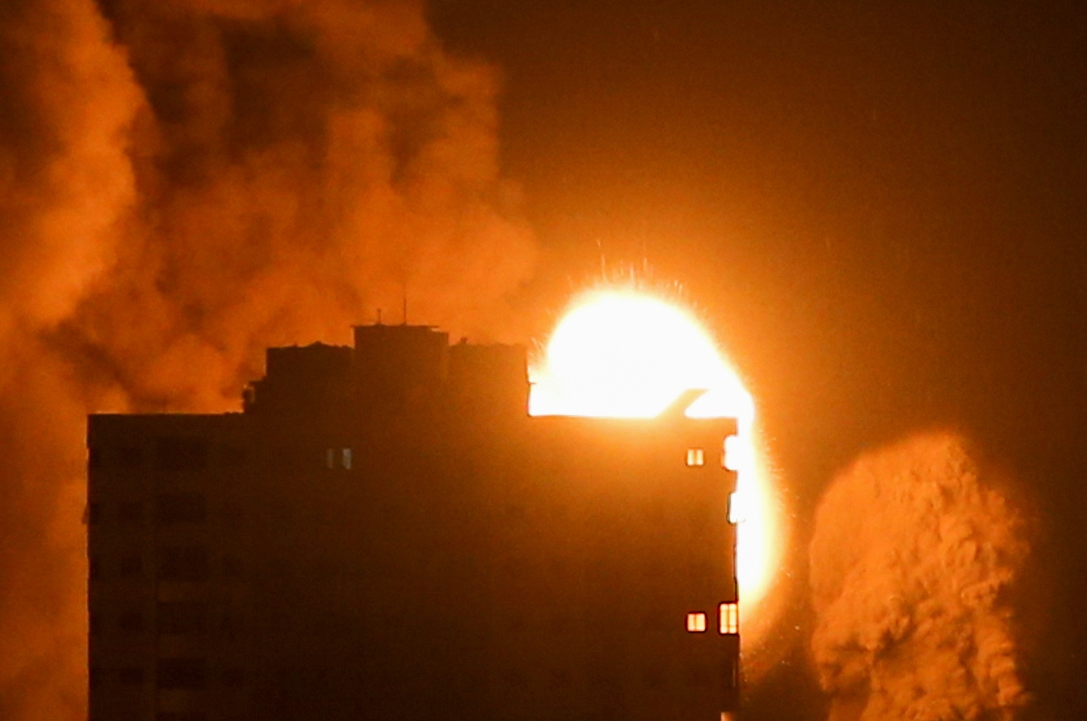 تصاعد النيران والدخان فوق المباني في مدينة غزة، جراء استهداف طائرات الاحتلال الإسرائيلي القطاع الفلسطيني، 17 مايو 2021. (رويترز / إبراهيم أبو مصطفى)