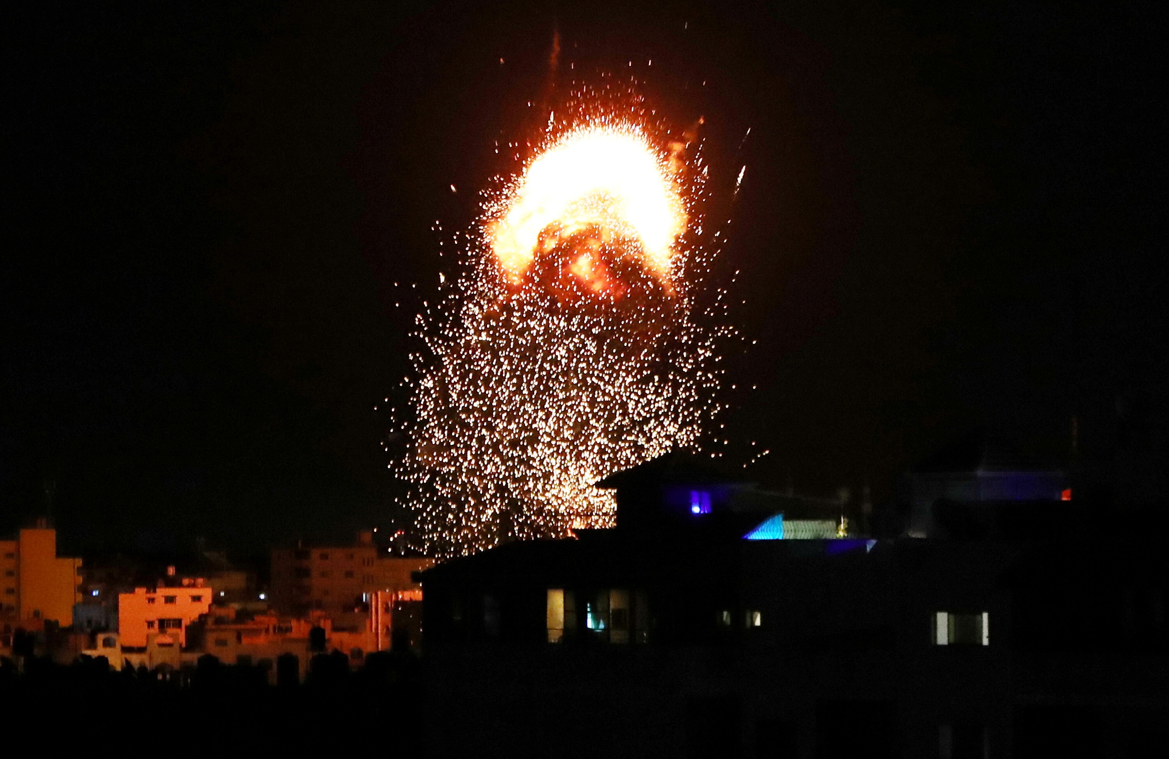 دخان ونيران متصاعدة فوق مبنى في مدينة غزة بعد قصف إسرائيلي، 17 أيار/مايو 2021. (محمد سالم/رويترز)