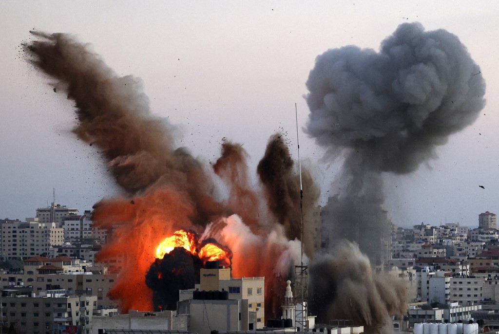 تصاعد الدخان والنار بعد غارة جوية لجيش الاحتلال الإسرائيلي على مدينة غزة، 14 أيار/مايو 2021. (محمود همص/ أ ف ب)