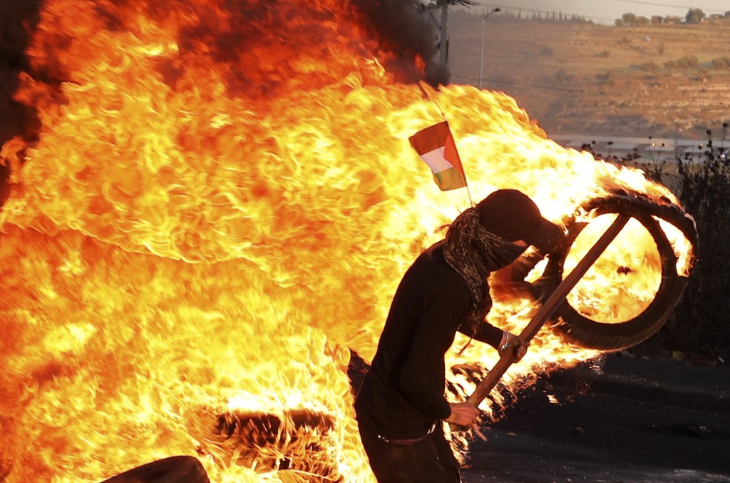 متظاهرون فلسطينيون يحرقون الإطارات خلال الاحتجاج على التوتر في القدس في الضفة الغربية المحتلة. 17 مايو 2021.(أ ف ب)