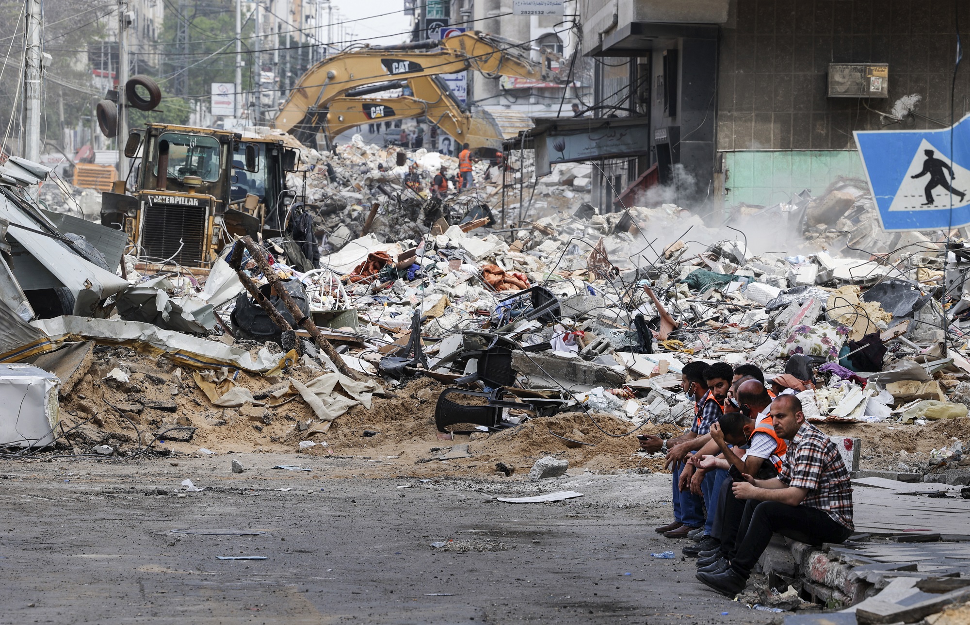 آلة حفر تزيل ركام مبنى مدمر في حي الرمال السكني في مدينة غزة بعد قصف إسرائيلي مكثف. 16/05/2021. (محمود حمس / أ ف ب)