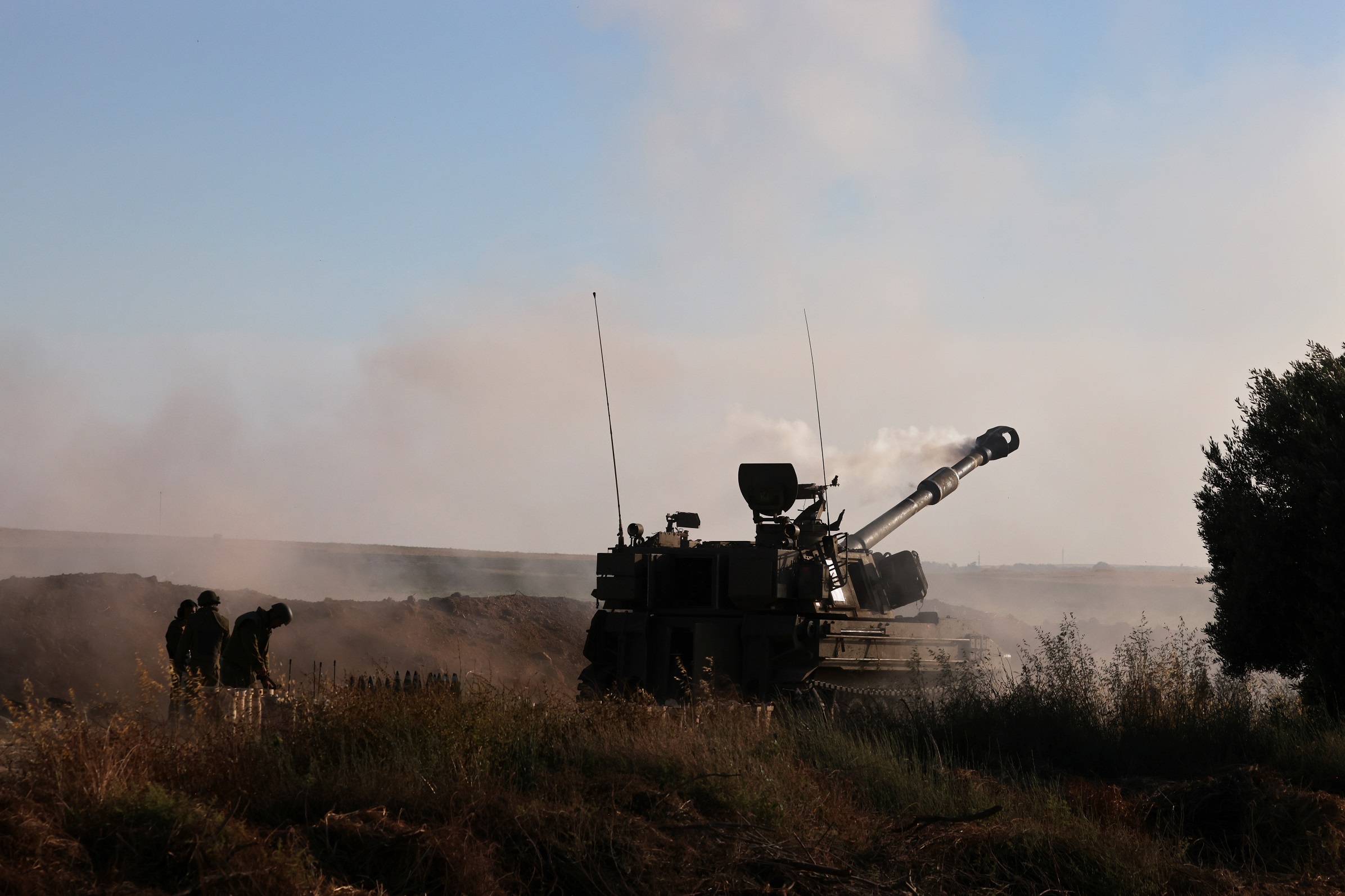 جنود إسرائيليون يعملون في وحدة مدفعية أثناء قصف قطاع غزة بالقرب من الحدود. (رويترز)
