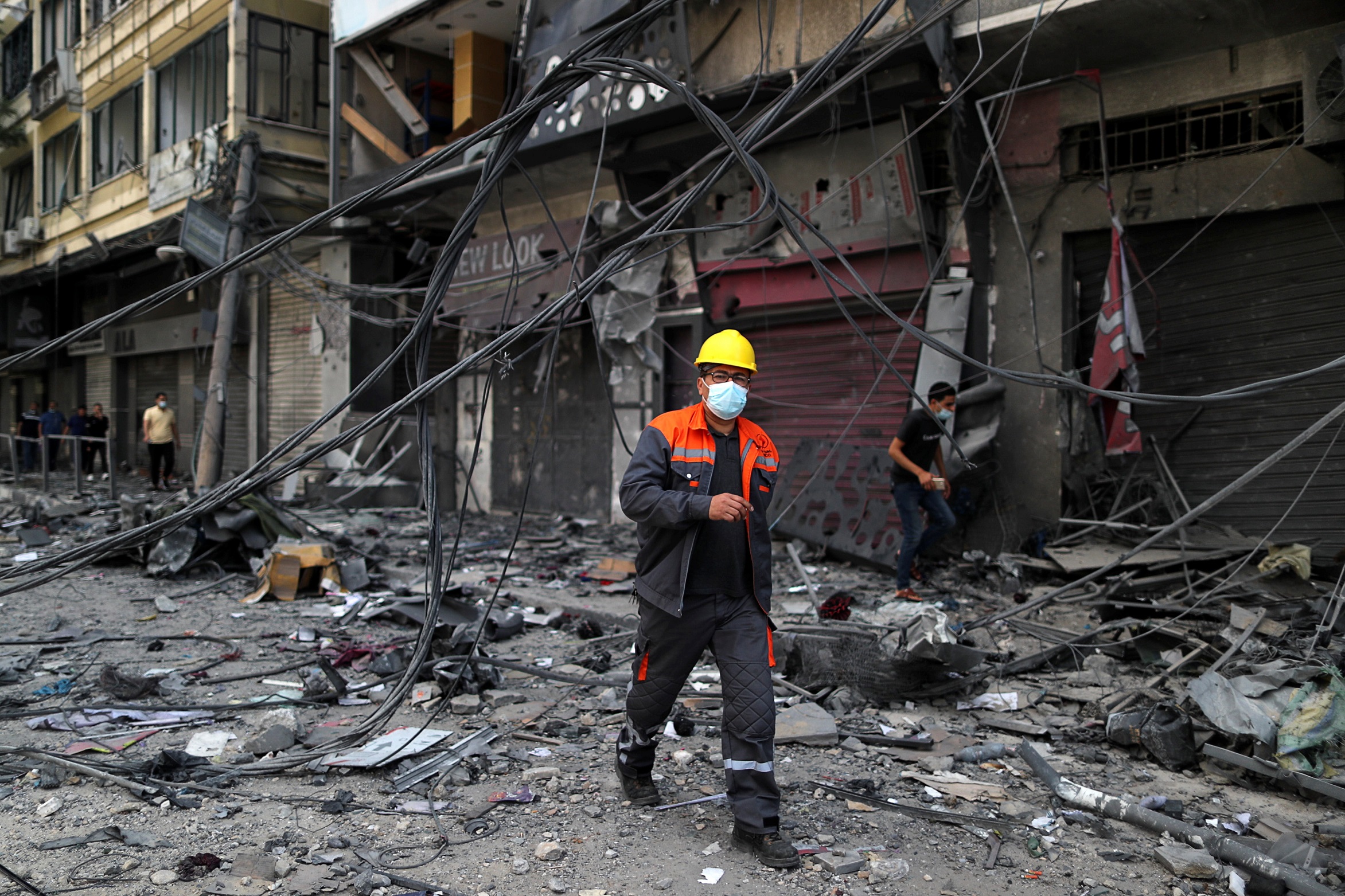 موظف كهرباء في الموقع الذي دمر فيه مبنى برج في غارات جوية إسرائيلية في مدينة غزة، 13 أيار/مايو 2021. (صهيب سالم / رويترز)
