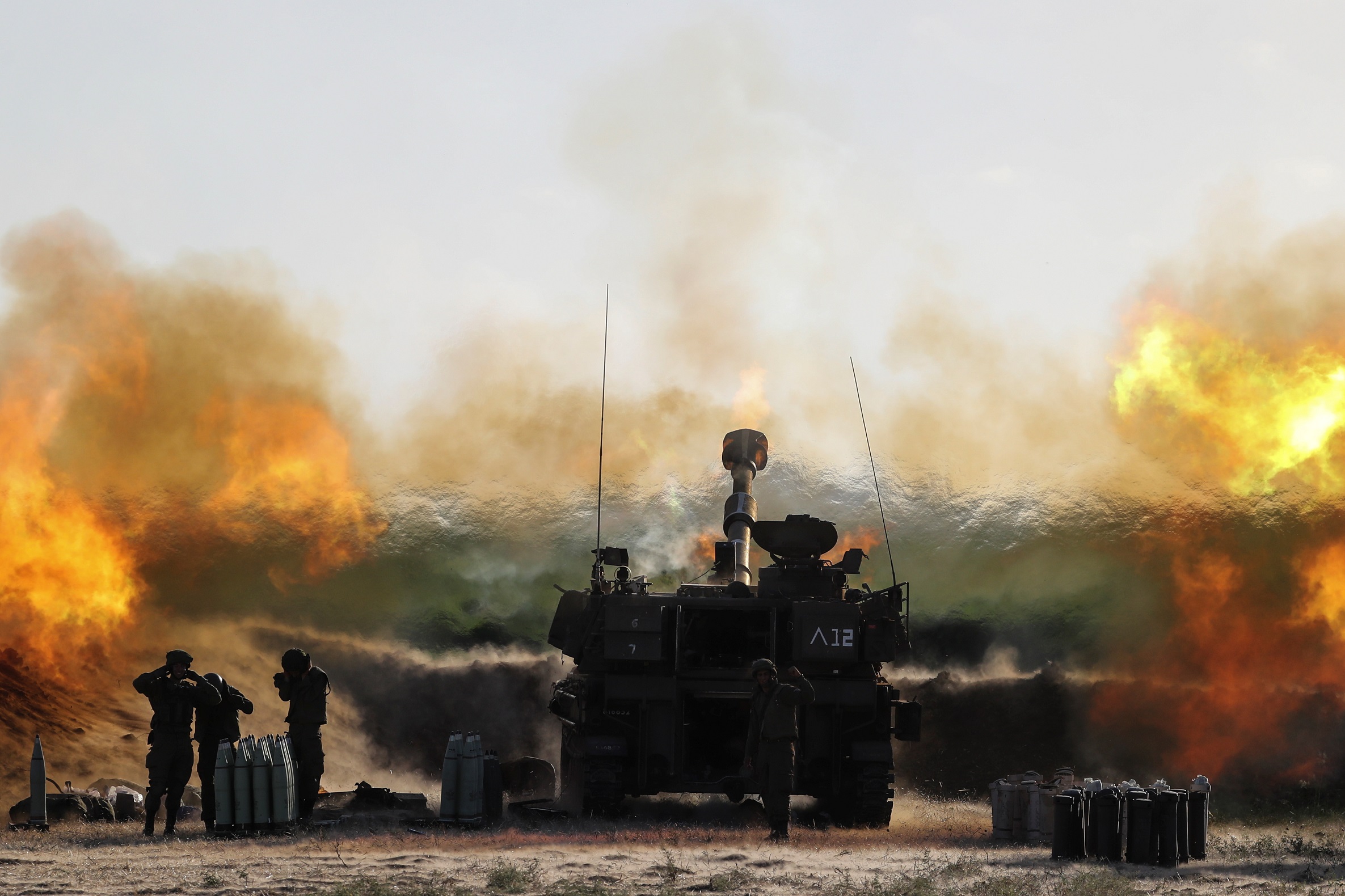 جنود إسرائيليون يعملون في وحدة مدفعية في أثناء قصفها بالقرب من الحدود مع قطاع غزة، 19 أيار/مايو 2021. (رويترز)