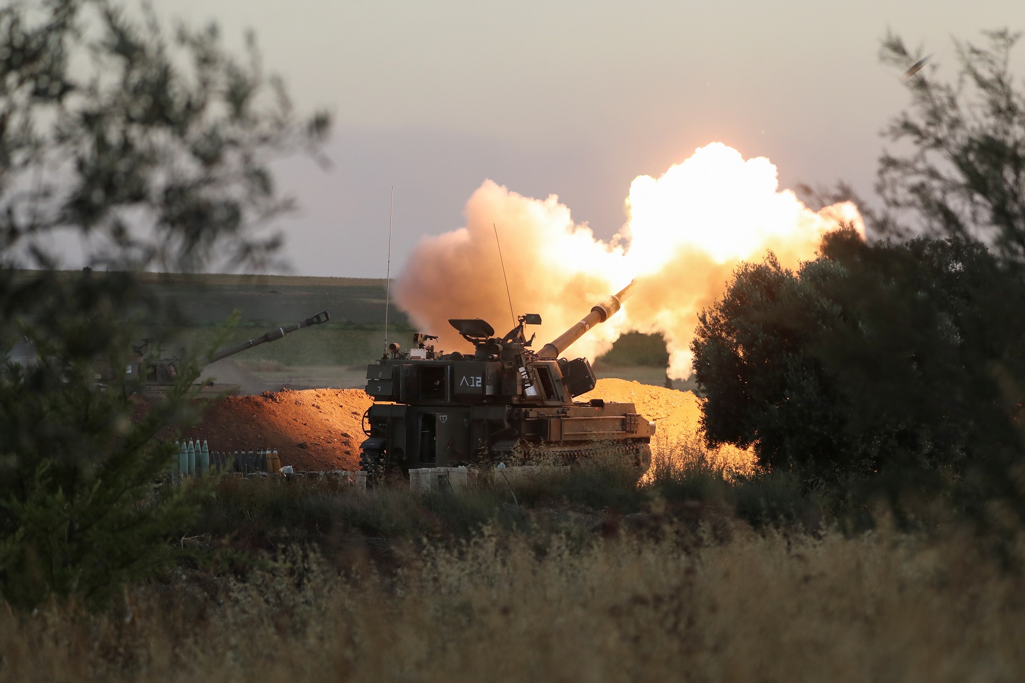 دبابة تابعة لجيش الاحتلال الإسرائيلي تقصف قطاع غزة، 19 أيار/مايو 2021، (رويترز / عمار عوض)