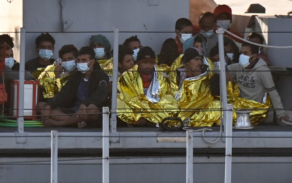 مهاجرون تم تسخينهم بواسطة بطانيات الطوارئ على متن قارب تابع لوكالة إنفاذ القانون الإيطالية، 17 أيار/مايو 2021. (أ ف ب)