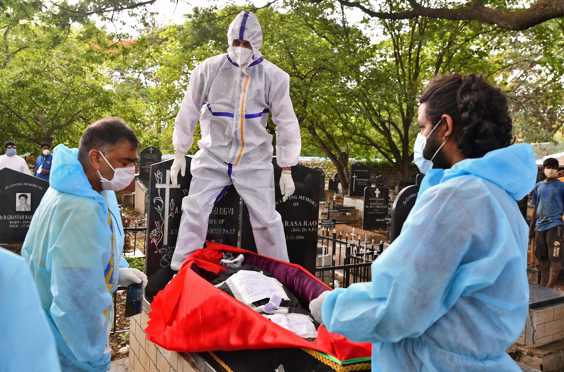 متطوع يرتدي معدات الحماية الشخصية ويستعد لدفن جثة شخص مات من فيروس كورونا، في مقبرة في بنغالورو، الهند، 18 أيار/مايو 2021 (رويترز)