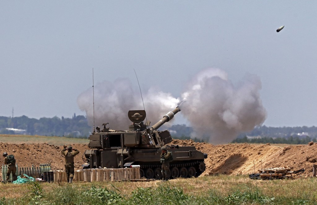 جنود الاحتلال الإسرائيلي يطلقون قذائف مدفعية باتجاه قطاع غزة من مواقعهم على طول الشريط الحدودي مع القطاع. 19/05/2021. (جاك كويز / أ ف ب)
