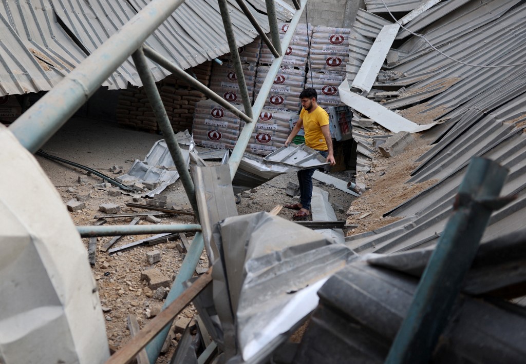 فلسطيني يسير في مصنع دُمر بعد غارة جوية إسرائيلية في جباليا شمالي قطاع غزة، 20 أيار/مايو 2021. (أ ف ب)