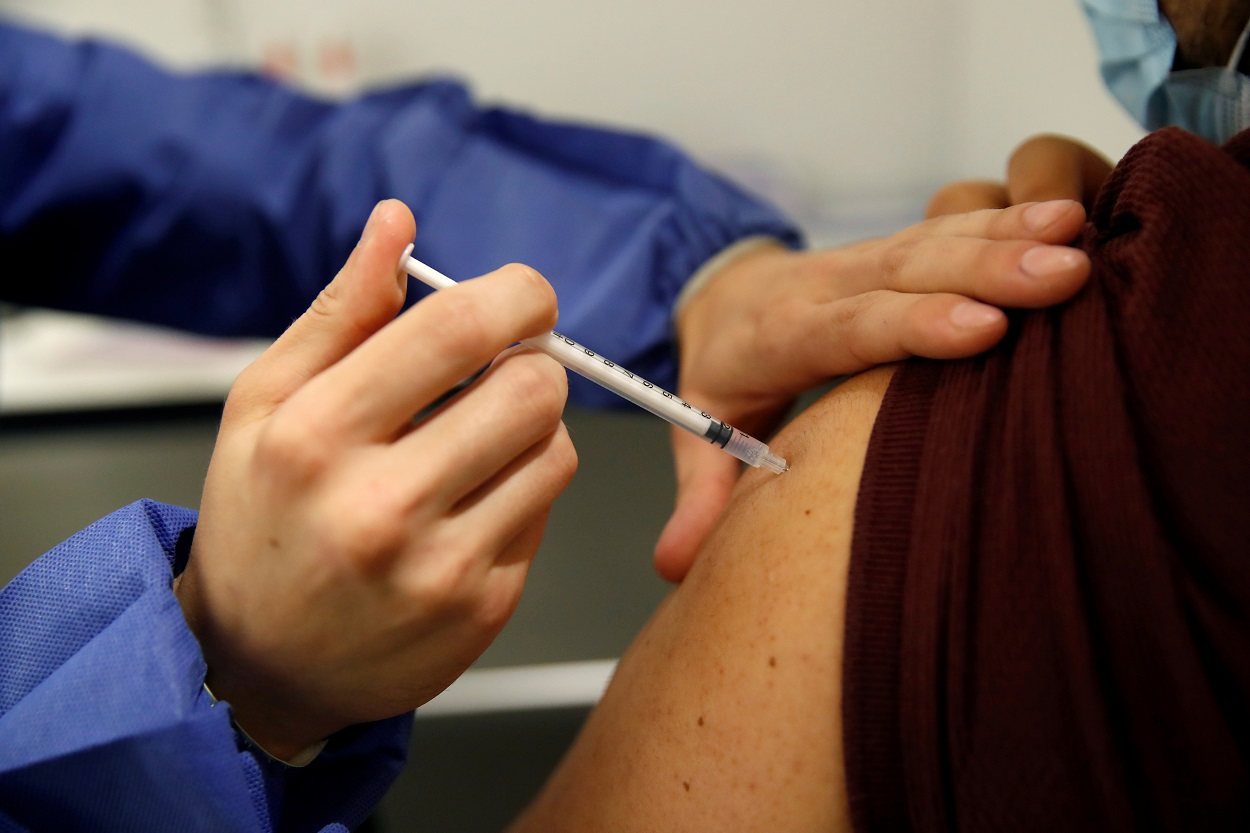 عامل طبي يعطي جرعة من اللقاح ضد فيروس كورونا، مركز تطعيم في باريس كجزء من حملة التطعيم في فرنسا، 12 أيار/مايو 2021. (رويترز)