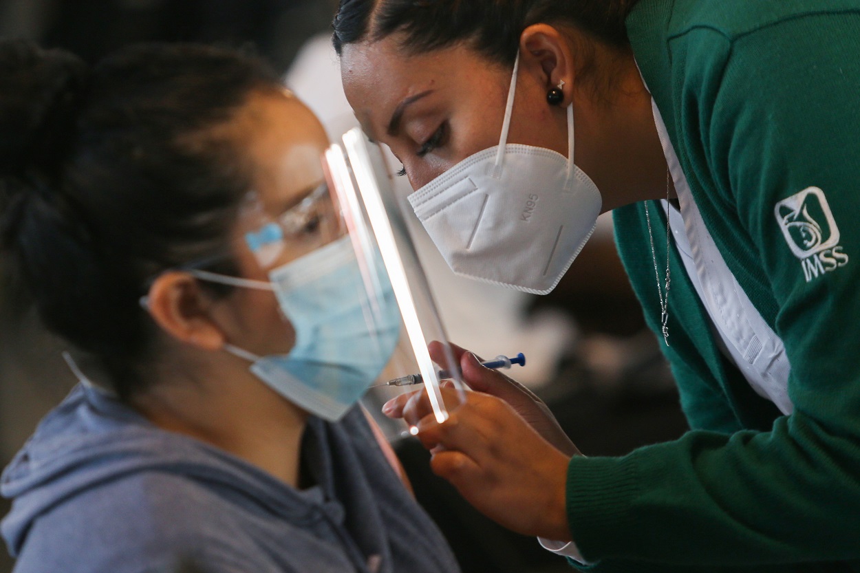 عامله صحيه تعطي جرعة من اللقاح المضاد للفيروس، أثناء تلقيح جماعي للمعلمين وموظفي المدارس، في مكسيكو سيتي، المكسيك، 18 أيار/مايو 2021. (رويترز)