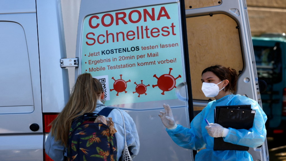 عاملة في القطاع الطبي تتحدث إلى امرأة في مركز اختبار متنقل لفيروس كورونا عند مدخل حديقة تمبلهوفر فيلد في برلين. 09/05/2021. (ديفيد جانون / أ ف ب)