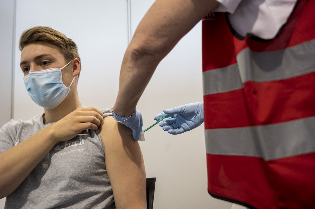 شاب يتلقى لقاح بيونتيك-فايزر في مركز تطعيم تابع لشركة مواد كيميائية في هاناو غربي ألمانيا وسط جائحة فيروس كورونا. 19/05/2021. (توماس لونيس / أ ف ب)