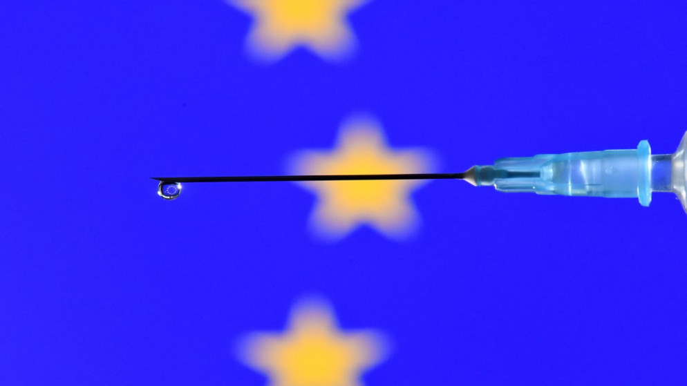 صورة تعبيرية لقطرة من لقاح مضاد لكورونا تسقط من حقنة وينعكس عليها علم الاتحاد الأوروبي. (أ ف ب)