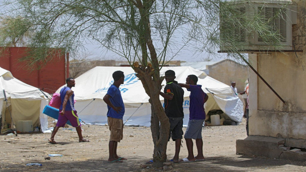 إثيوبيون يقفون تحت ظل شجرة في مخيم أم قرقور للاجئين في شرق السودان حيث وجدوا ملاذاً مؤقتاً، 23 أيار/مايو 2021 (أ ف ب)