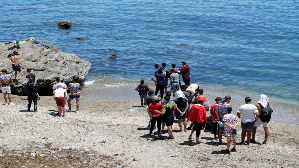 مهاجرون يقفون على شاطئ الفنيدق بالقرب من سبتة في المغرب، 19 أيار/مايو 2021. (رويترز / شيرين طلعت)