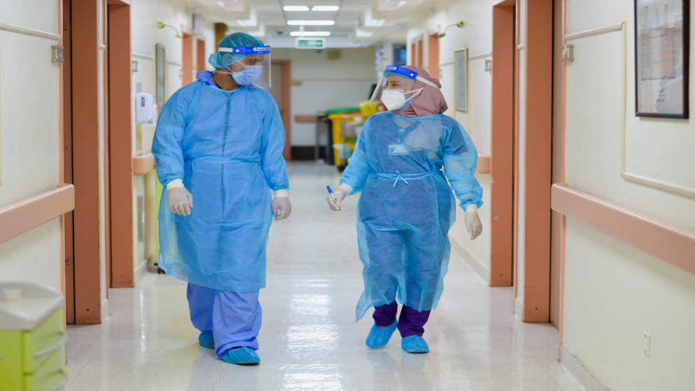 اثنان من الكوادر الصحية في مستشفى خاص في عمان، 23 آذار/مارس 2021. (رويترز)