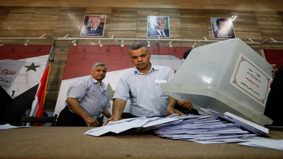 موظف اقتراع يفرغ صندوق اقتراع لفرز الأصوات بعد إغلاق مراكز الاقتراع خلال الانتخابات الرئاسية في دمشق، سوريا، 27 أيار/مايو 2021. (رويترز / عمر صناديقي)