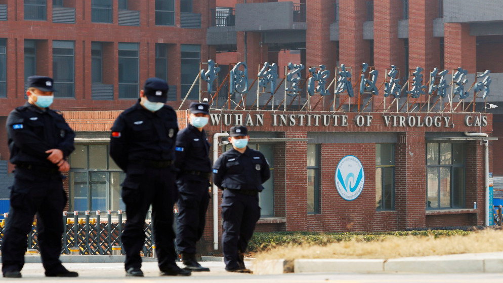 أفراد أمن يراقبون خارج معهد ووهان لعلم الفيروسات أثناء زيارة فريق منظمة الصحة العالميةللتحقيق في أصول فيروس كورونا في الصين، 3 شباط/فبراير 2021 (رويترز)