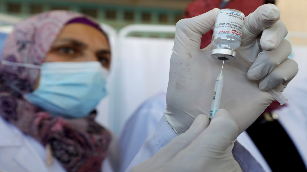 عاملة في القطاع الصحي الفلسطيني خلال تحضير جرعة من لقاح مضاد لفيروس كورونا في الضفة الغربية المحتلة. 3 كانون الثاني/يناير 2021 (رويترز)
