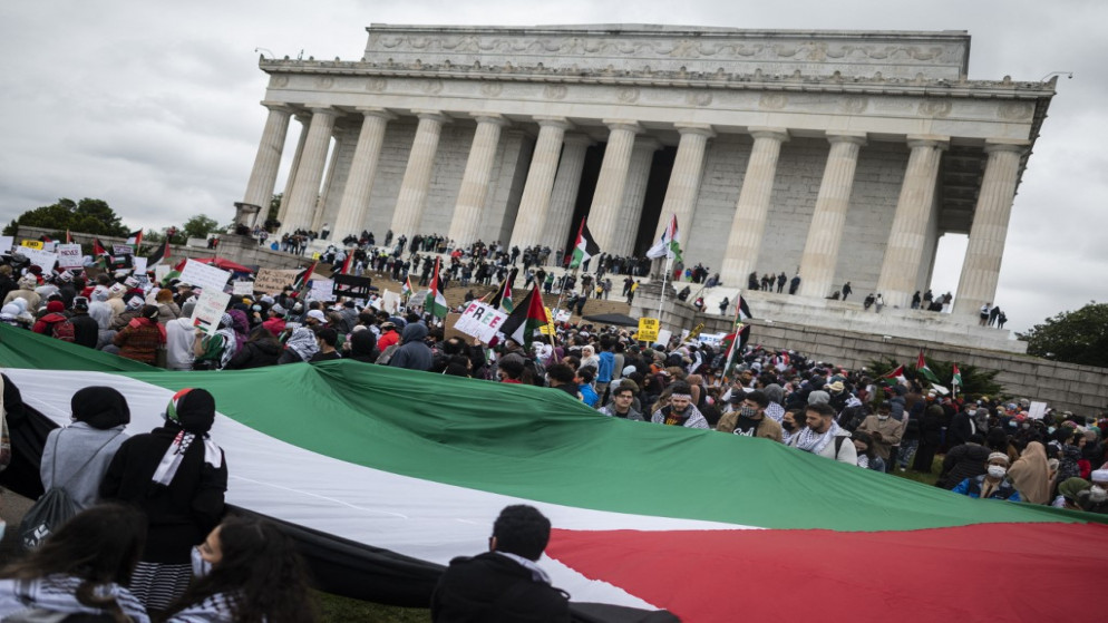 أشخاص يلوحون بالأعلام الفلسطينية، خلال مظاهرة للتعبير عن الدعم لشعب فلسطين، أثناء تجمعهم في نصب لنكولن التذكاري في واشنطن العاصمة، 29 أيار/مايو 2021. (أ ف ب)