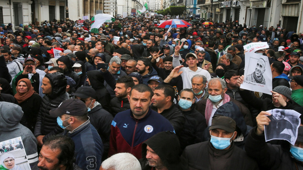 متظاهرون يسيرون خلال مظاهرة للمطالبة بالتغيير السياسي في الجزائر العاصمة، 16 نيسان/أبريل 2021. (رويترز)
