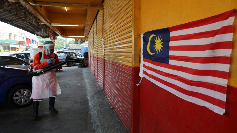 عامل يرش متجرا وسط تفشي مرض فيروس كورونا في كوالالمبور، ماليزيا، 24 أكتوبر، 2020.( رويترز / ليم هيوي تنغ)