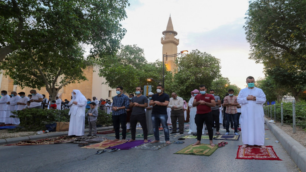 أشخاص يؤدون الصلاة، خارج مسجد الملك عبد العزيز، الرياض، المملكة العربية السعودية، 13 أيار/مايو 2021. (رويترز)
