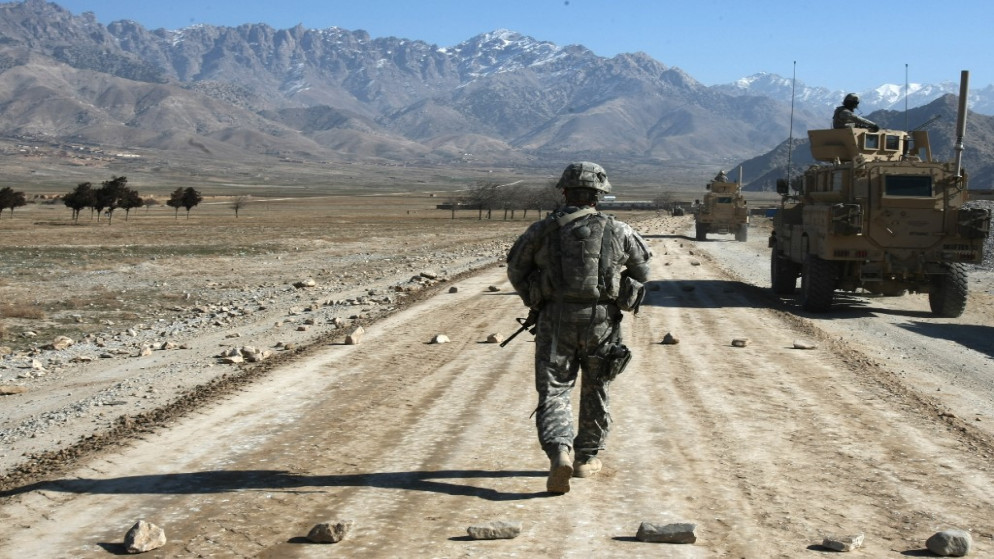 جندي أميركي من فرقة حماية تابعة لفريق إعادة الإعمار الإقليمي يسير على طول طريق قيد الإنشاء بالقرب من باغرام، 11 يناير / كانون الثاني 2010. (أ ف ب)