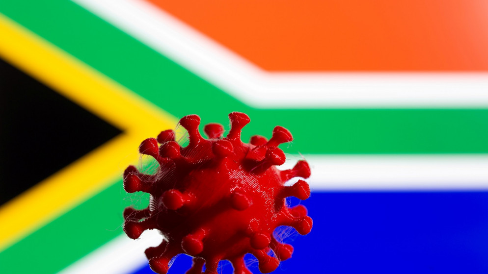 يظهر نموذج لفيروس كورونا مطبوع ثلاثي الأبعاد أمام علم جنوب إفريقيا (رويترز)
