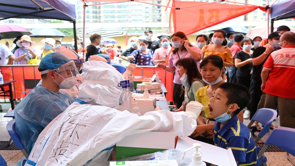 عامل طبي يأخذ مسحة من طفل أثناء اختبار جماعي لمرض فيروس كورونا في موقع اختبار مؤقت في الصين، 30 أيار/مايو 2021، (رويترز)