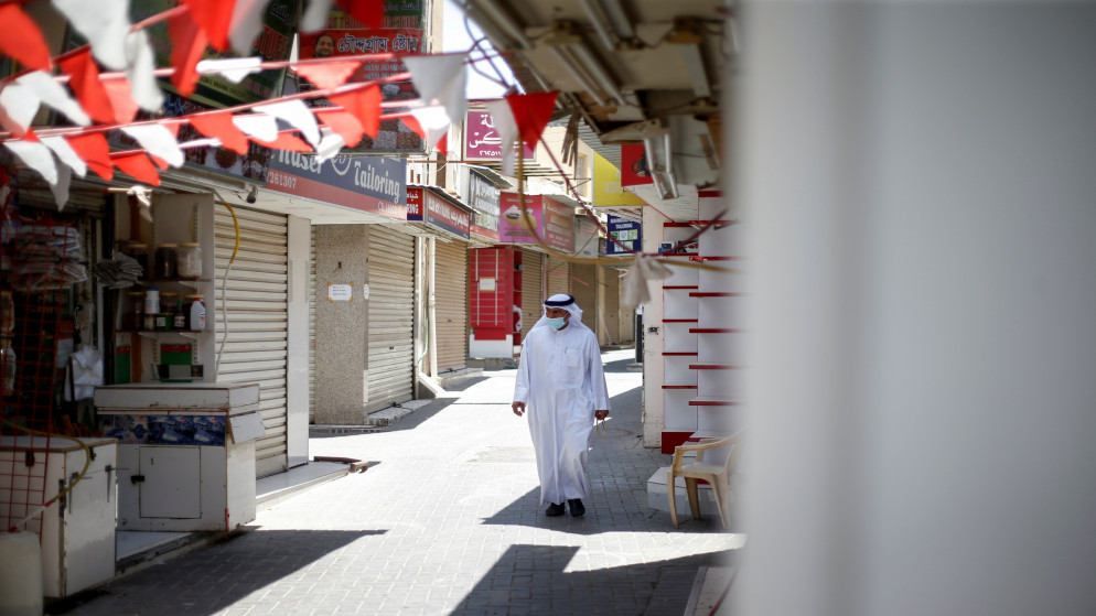 رجل يمشي بالقرب من متاجر مغلقة في العاصمة البحرينية المنامة، 3 حزيران/يونيو 2021. (رويترز)
