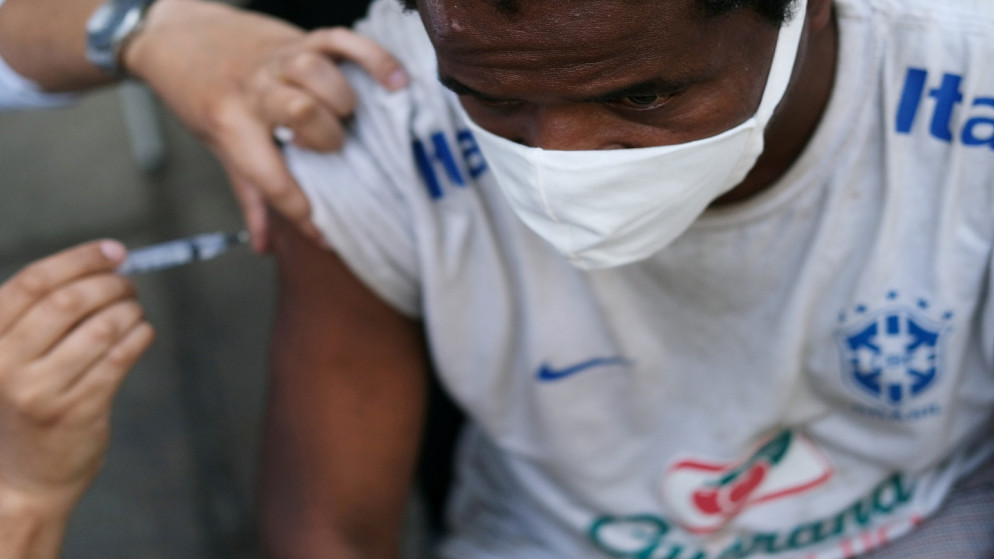رجل يتلقى لقاح واق من كورونا خلال حملة تطعيم للمشردين في وسط مدينة ريو دي جانيرو بالبرازيل، 27 مايو / أيار 2021. (رويترز / ريكاردو مورايس)