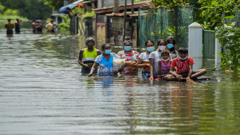 يشق السكان طريقهم عبر مياه الفيضانات بعد هطول أمطار موسمية غزيرة في كيلانيا، على مشارف كولومبو، سريلانكا، 6 يونيو 2021.(أ ف ب)