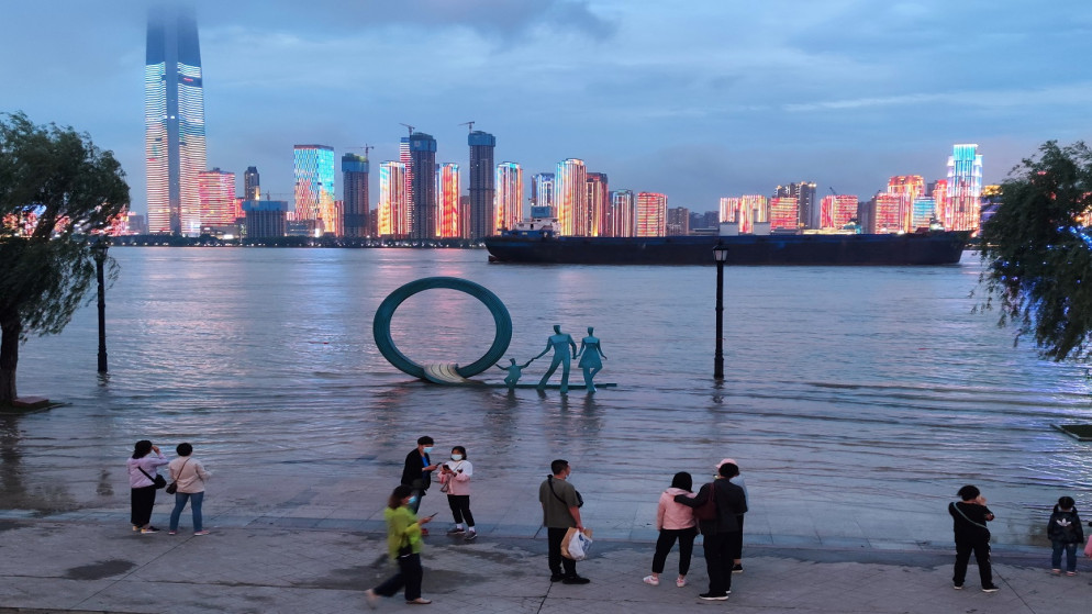 يقف أشخاص في حديقة على ضفاف نهر اليانغتسي، ووهان، مقاطعة هوبي، الصين.  26 مايو 2021. (أ ف ب)