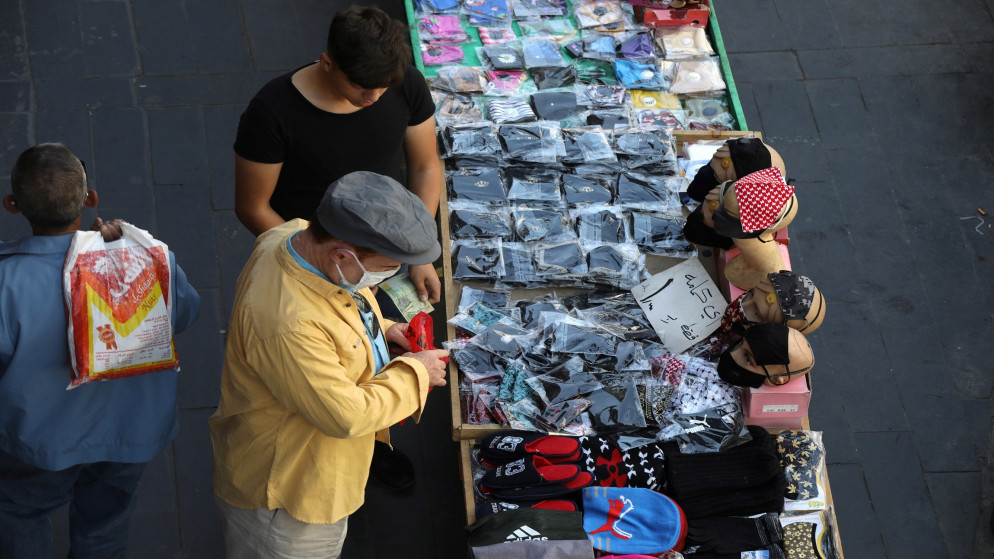 بائع متجول يعرض كمامات واقية في وسط مدينة عمّان. (رويترز)