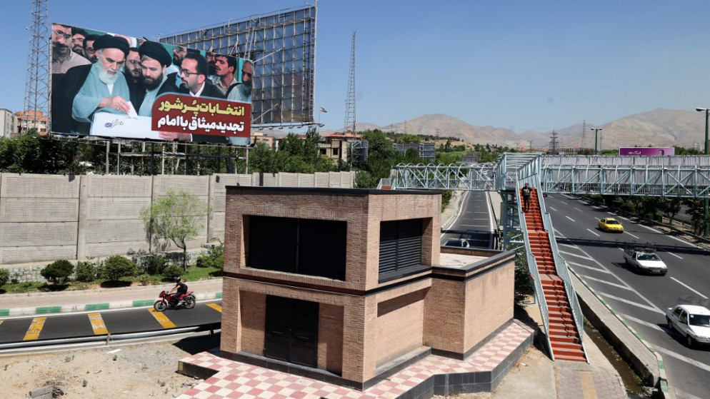 لوحة إعلانية تصور مؤسس إيران الخميني وهو يدلي بصوته في صندوق اقتراع. طهران. 8 يونيو 2021.(أ ف ب)